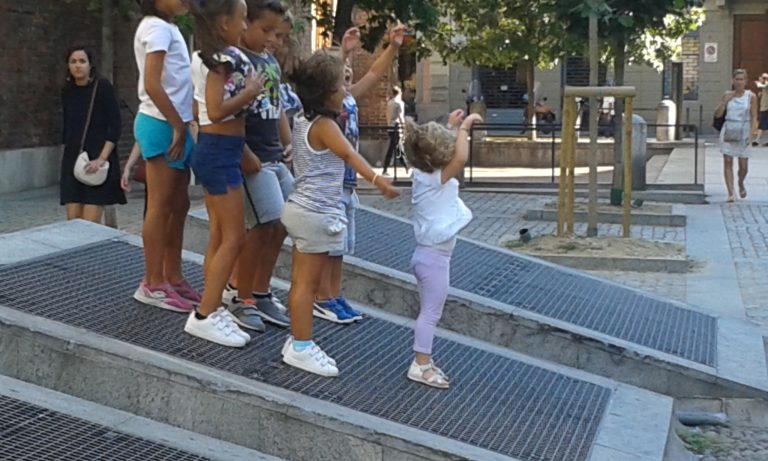 Le griglie di aerazione della metro diventano per i bambini un'occasione di gioco